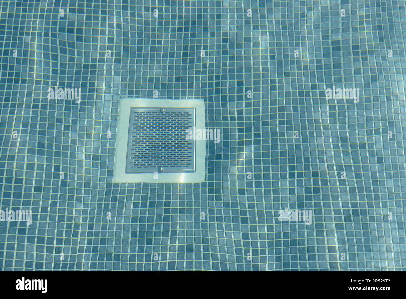 Floor of swimming poll covered with small blue tiles underwater with ...