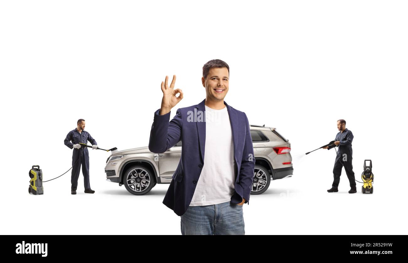 Male customer gesturing ok sign and car wash workers in cleaning a SUV