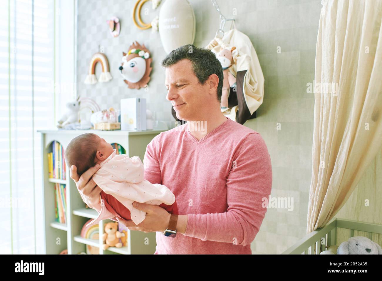 Father admiring newborn baby, dad holding tin newborn daughter Stock Photo