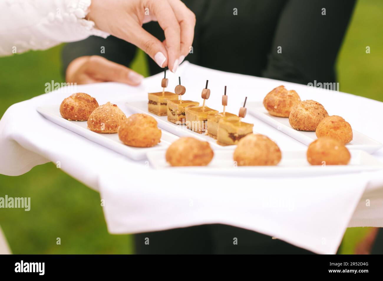 Waiter holding tray with fois gras and mini buns, catering for events Stock Photo