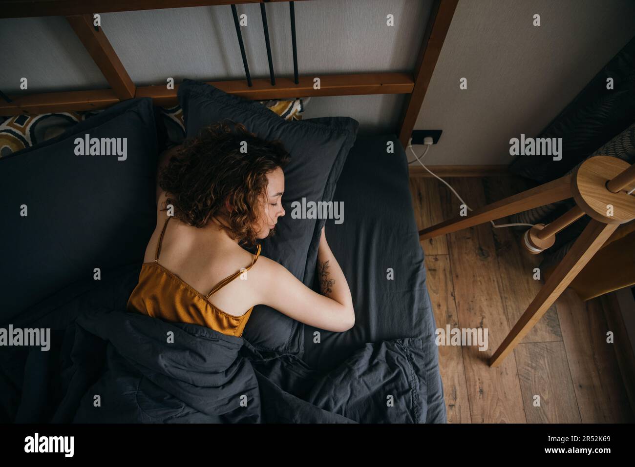 Woman sleeping on side on bed at home Stock Photo