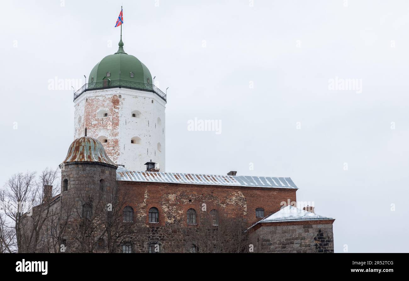 White tower of Vyborg Castle is under bright cloudy sky on a winter day. Russia Stock Photo