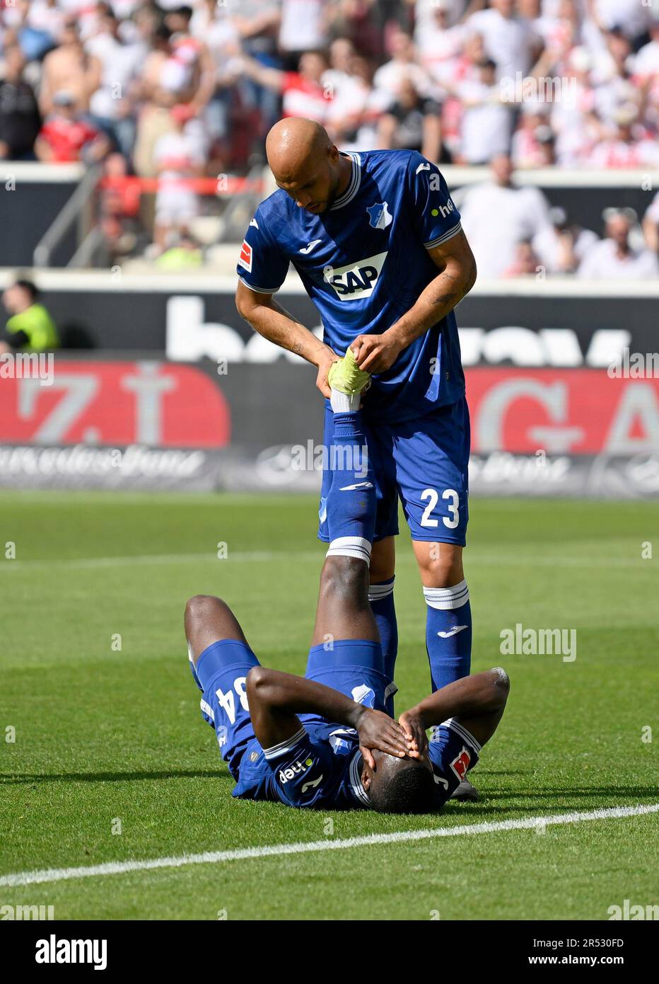 Calf cramp, John Anthony Brooks TSG 1899 Hoffenheim (23) helps Stanley Nsoki TSG 1899 Hoffenheim (34), Mercedes-Benz Arena, Stuttgart Stock Photo