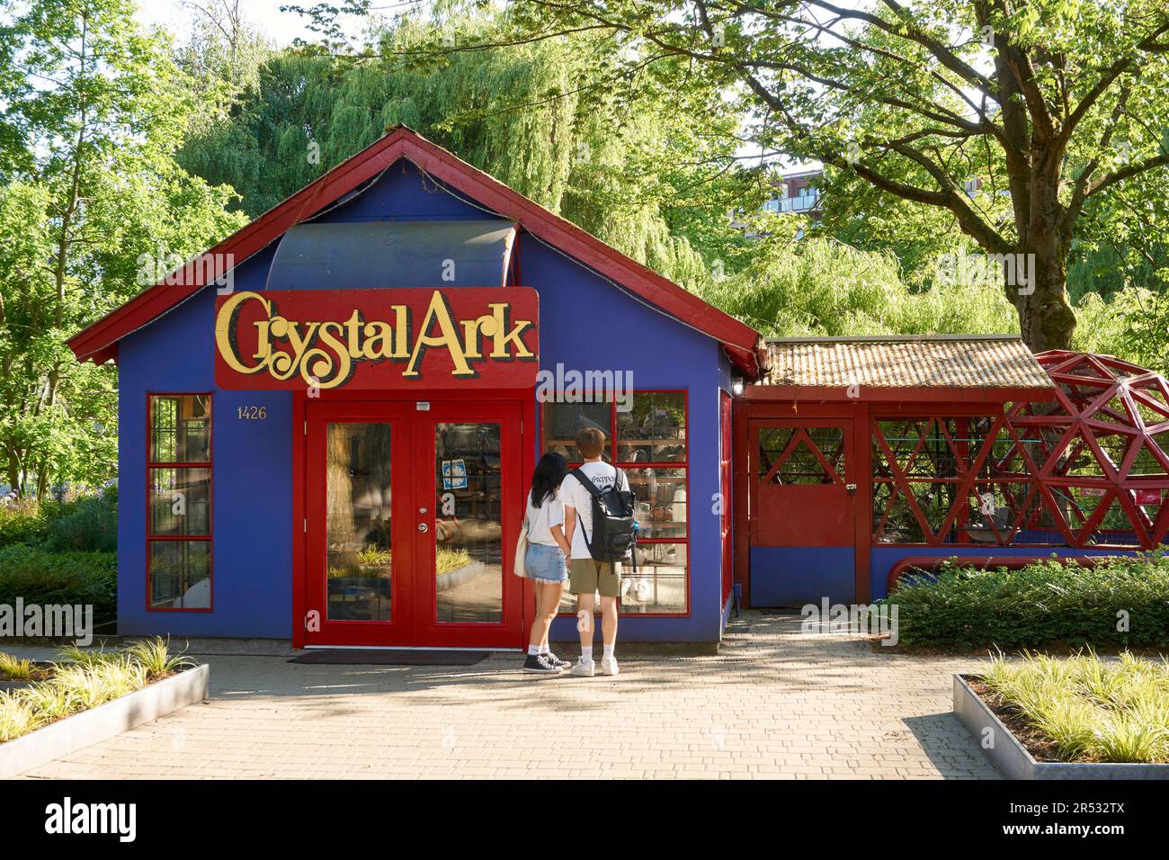 Young man and woman couple standing in front of the Crystal Ark shop  on Granville Island, Vancouver, BC, Canada Stock Photo
