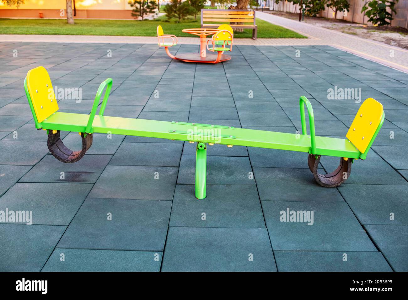 Empty seesaw on playground with soft rubber flooring in public park Stock Photo