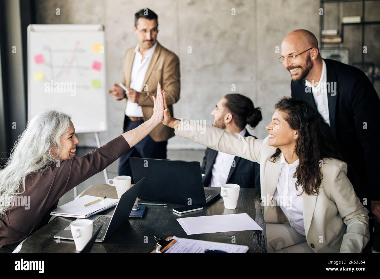 Joyful Coworkers Team Giving High Five During Meeting In Office Stock ...