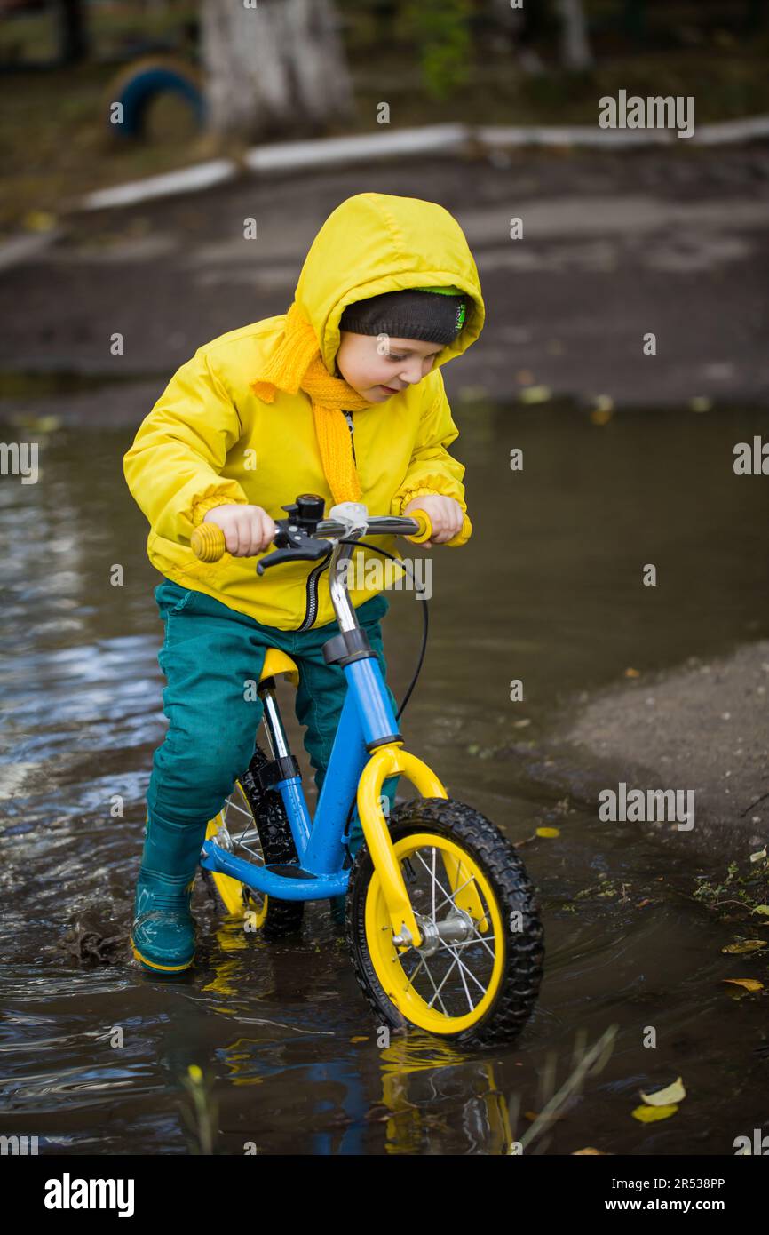 Little Boy In Rubber Boots Playing In Puddle Stock Photo Alamy