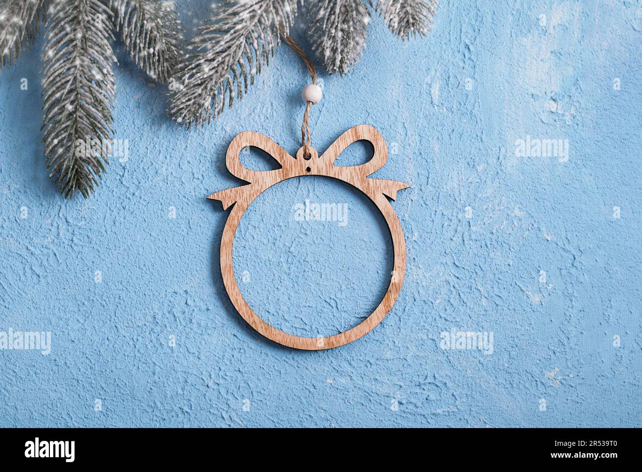Wooden Christmas ball on blue textured gypsum. Joinery tradition. New Year's background for building store. Building Material Used in Construction. Stock Photo