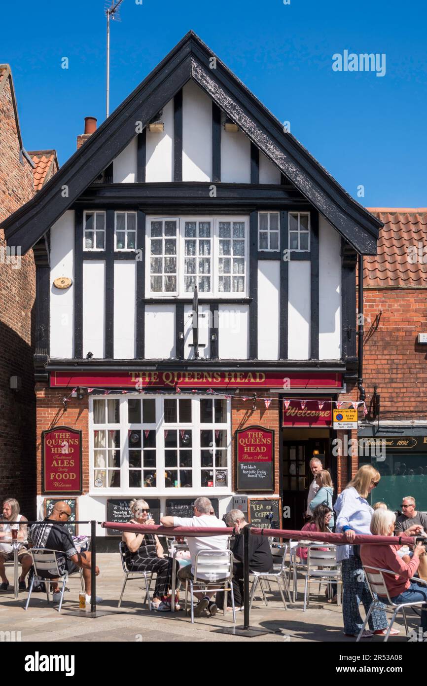 People sitting outside the Queens Head pub in Beverley, East Yorkshire, England, UK Stock Photo