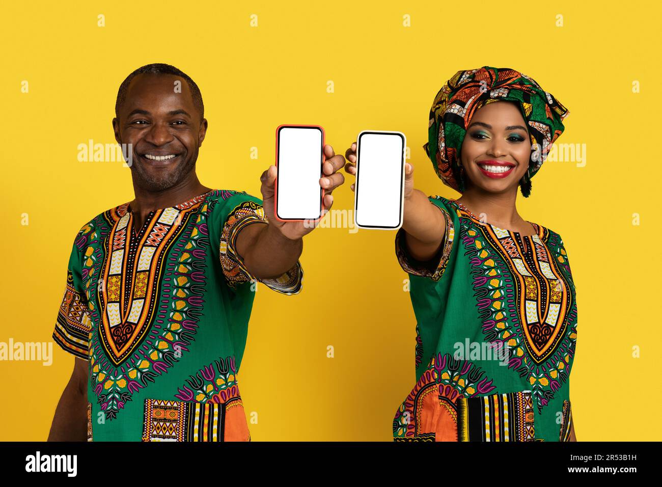 Beautiful black lovers showing cell phones with white screens Stock
