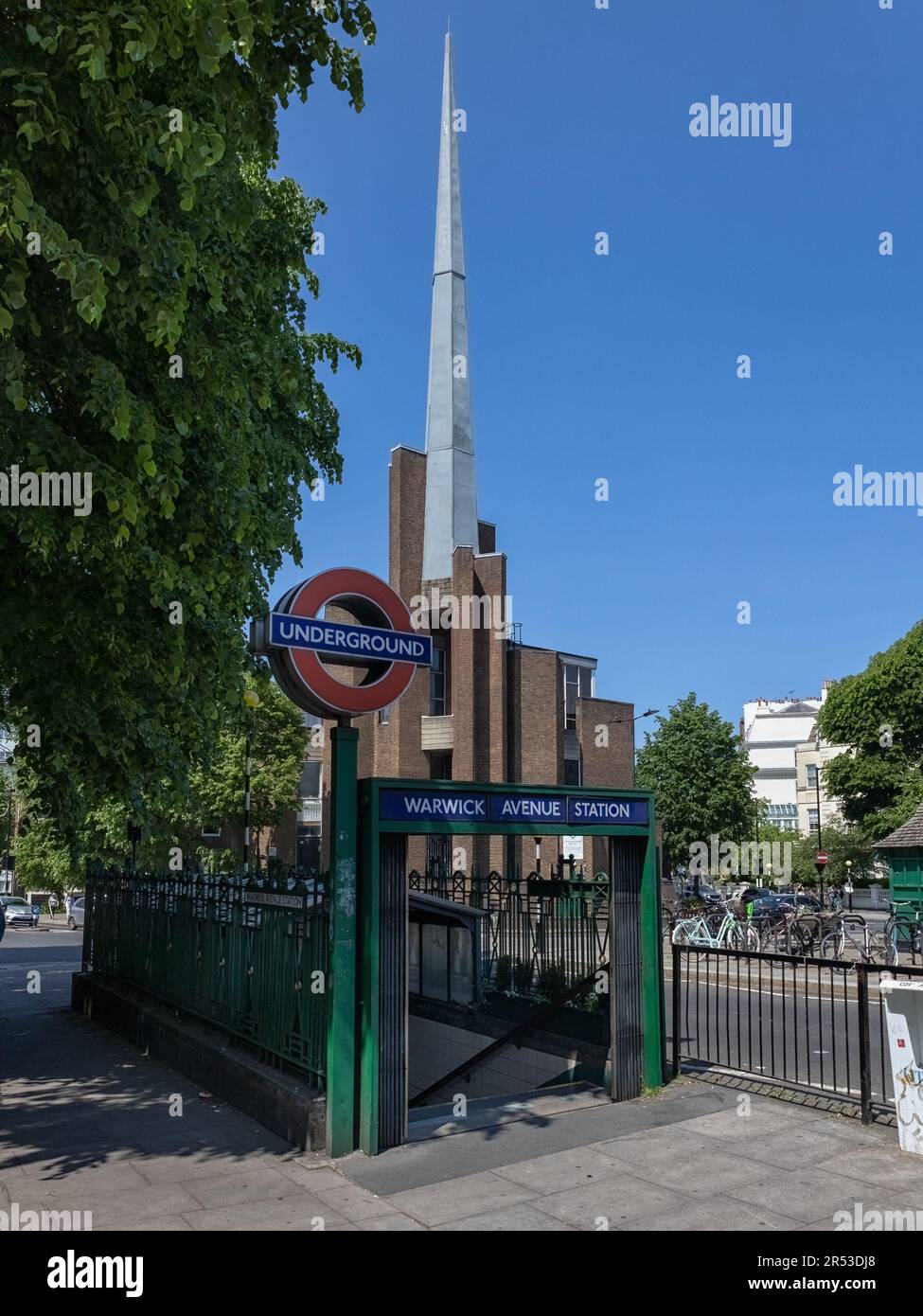 LONDON, UK - MAY 27, 2023:  View of entrance to Warwick Avenue underground station with St Saviour's Church in the background Stock Photo