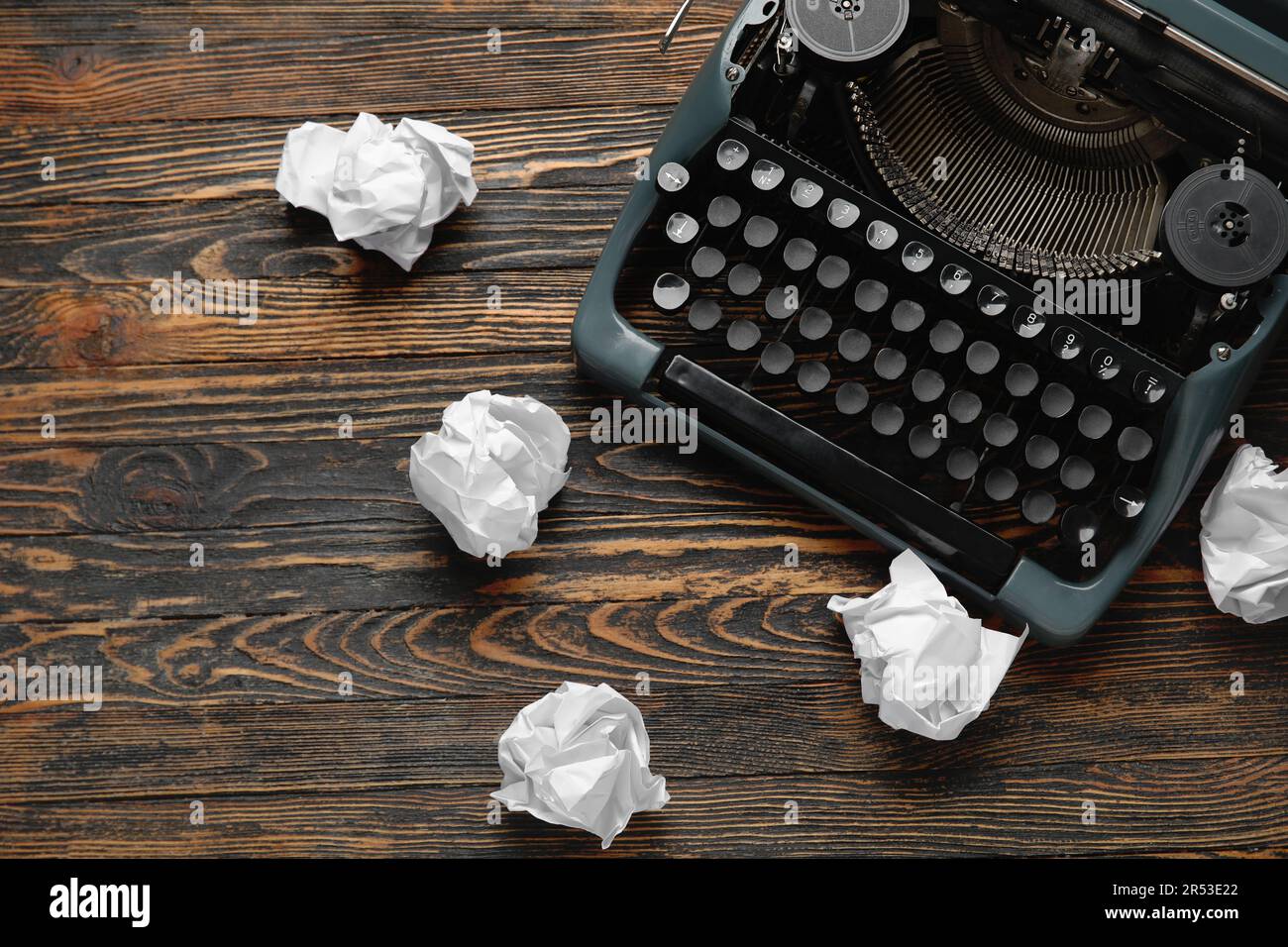 Small typewriter with keyboard in focus over a page of a book. Decoration  item. Concepts of reading, writing, old times, past. Close up. Blurred  background. Stock Photo