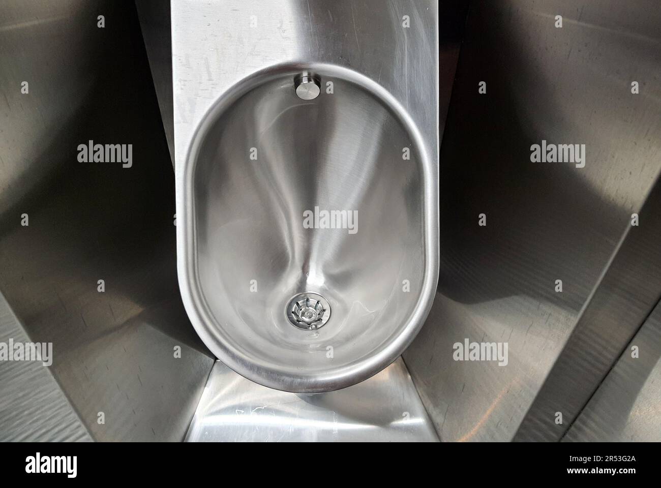 Sanitary metal urinal, toilet bowl in public bathroom with hygienic
