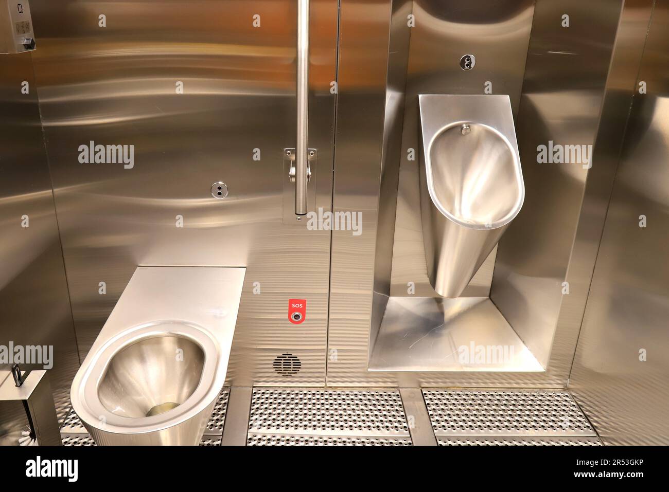 Plumbing metal urinal and toilet bowl in a public bathroom with