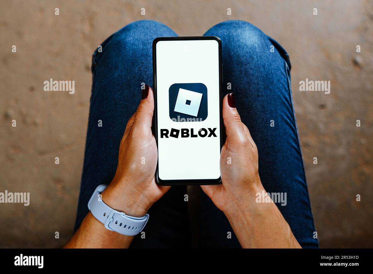 LONDON, UK - March 2021: Person holding a smartphone with Roblox game logo  Stock Photo
