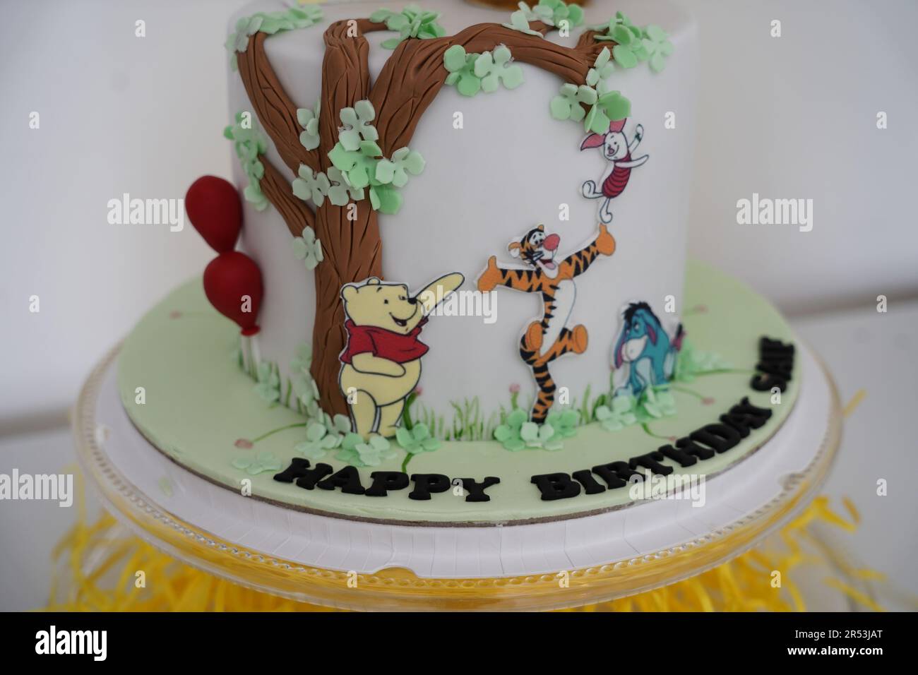 Winnie the Pooh birthday cake. Winnie the Pooh white birthday cake, a child birthday theme cake with sugar details. Stock Photo