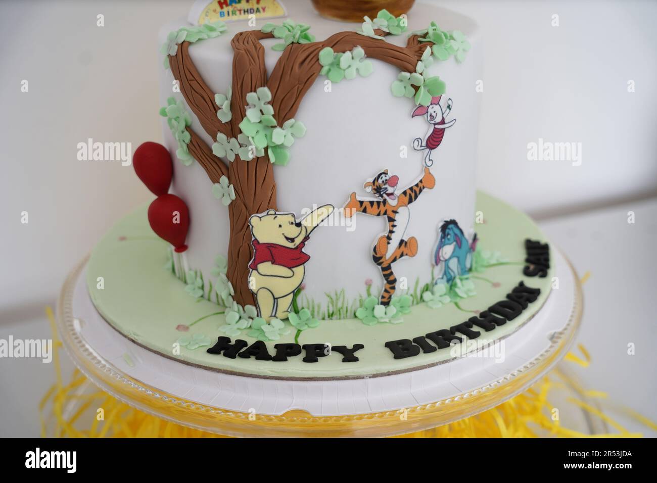 Winnie the Pooh birthday cake. Winnie the Pooh white birthday cake, a child birthday theme cake with sugar details. Stock Photo