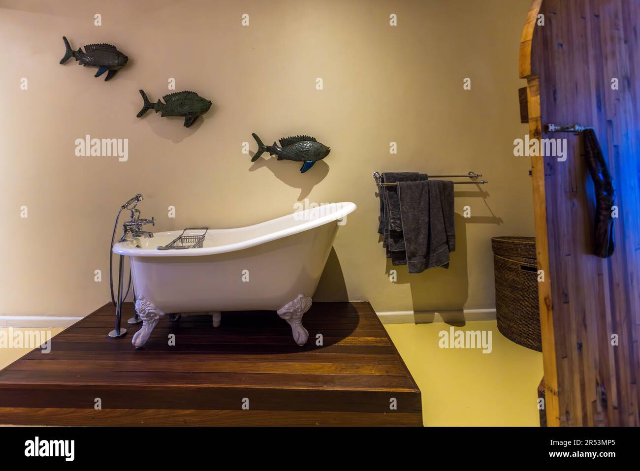 Bathroom with freestanding bathtub and fish as wall decoration in Pumulani Lodge, Robin Pope Safaris, on the shore of Lake Malawi, Cape Maclear, in Lake Malawi National Park. Fish made from recycled raw materials are a design element of Pumulani Luxury Beach Lodge - Robin Pope Safaris Stock Photo
