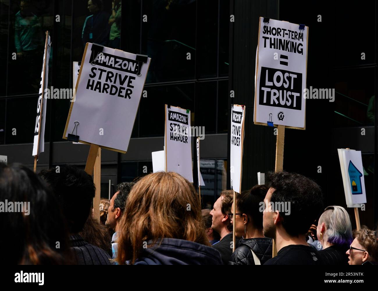 Amazon corporate workers hold picket signs while participating in a ...