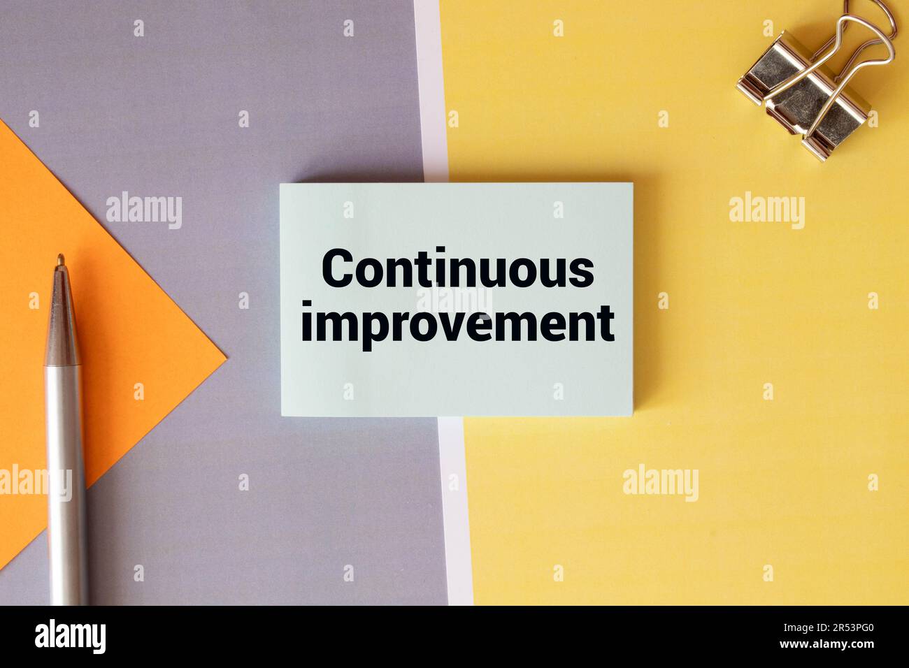 continuous improvement text message on white paper and office supplies