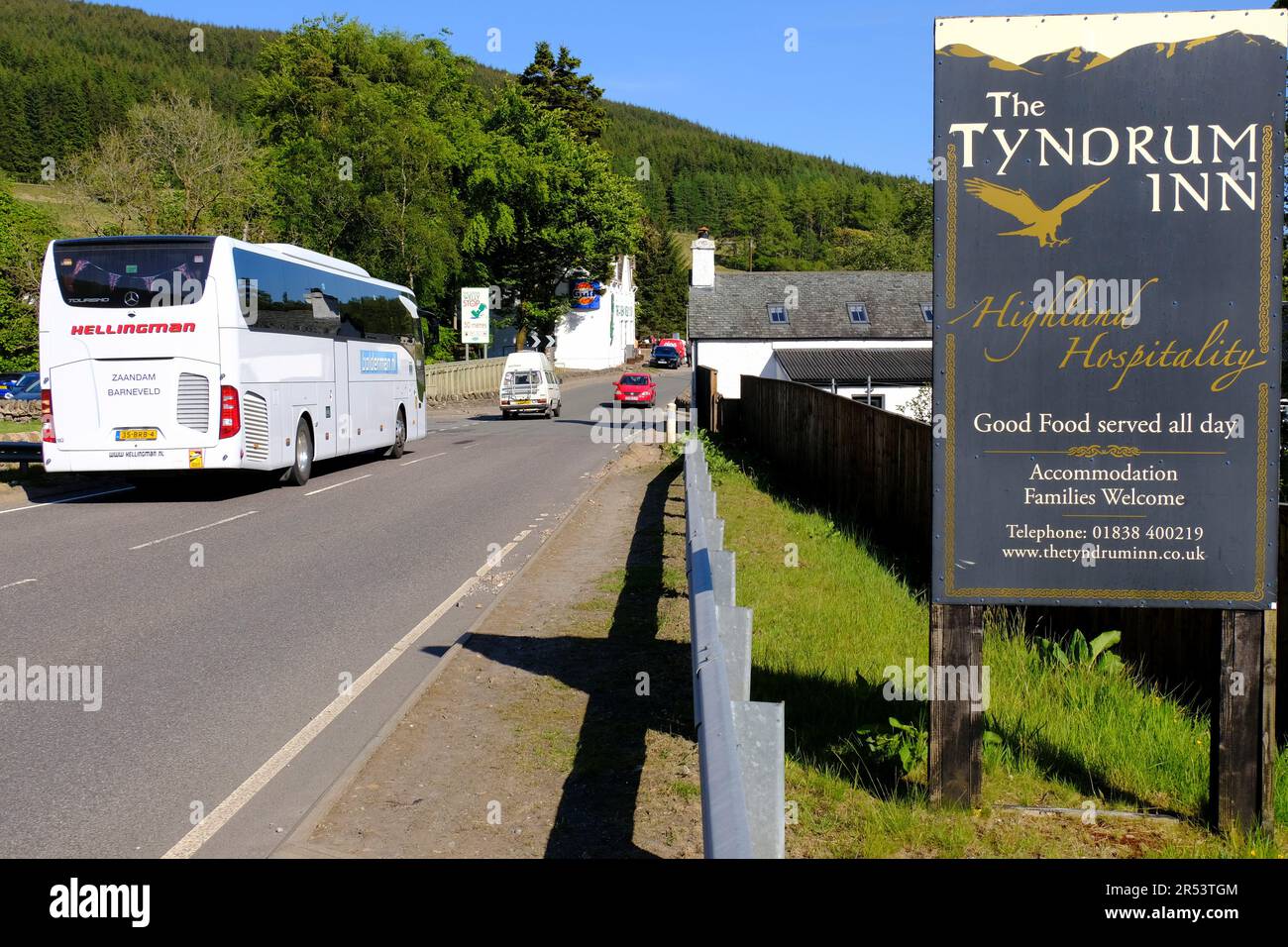 Clear blue skies and bright sunshine at Tyndrum, cars on the A82 road Tyndrum, Scotland Stock Photo