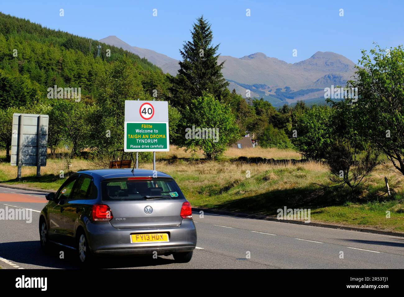 Clear blue skies and bright sunshine at Tyndrum, cars on the A82 road with views towards munro Stob Binnein and Cruach Ardrain, Tyndrum, Scotland Stock Photo