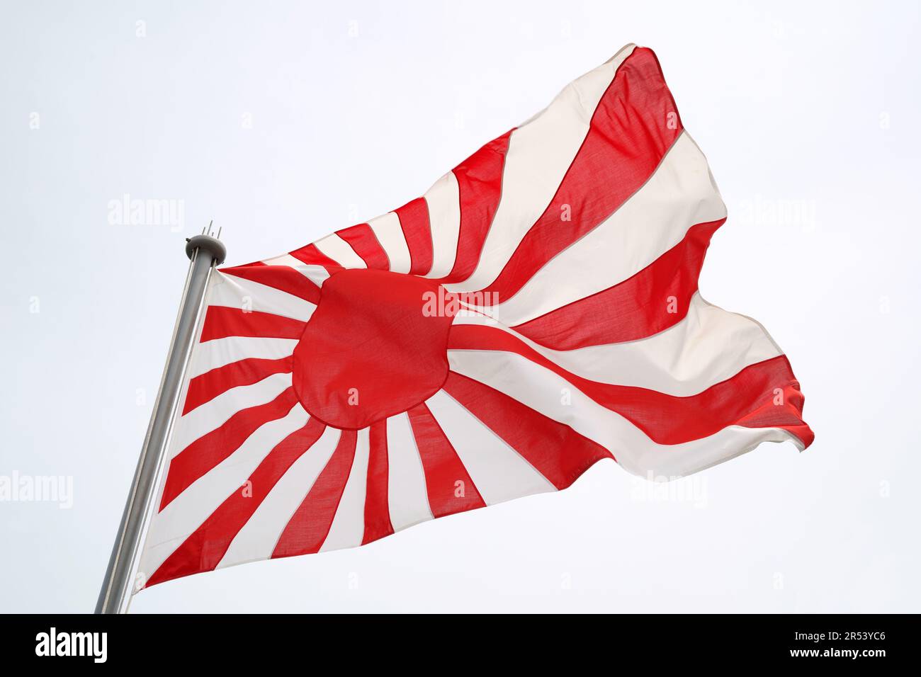 Japanese rising sun flag in the wind of the sky Stock Photo