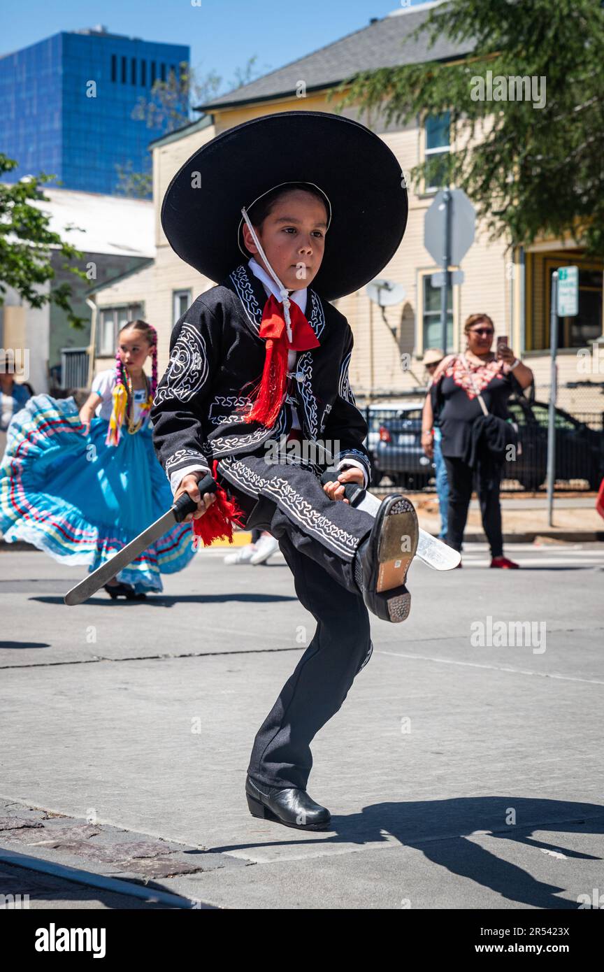 A young boy in traditional Mexican folkloric costume kicks up his heels during the Floricanto Family Festival, an event celebrating Latin American cul Stock Photo