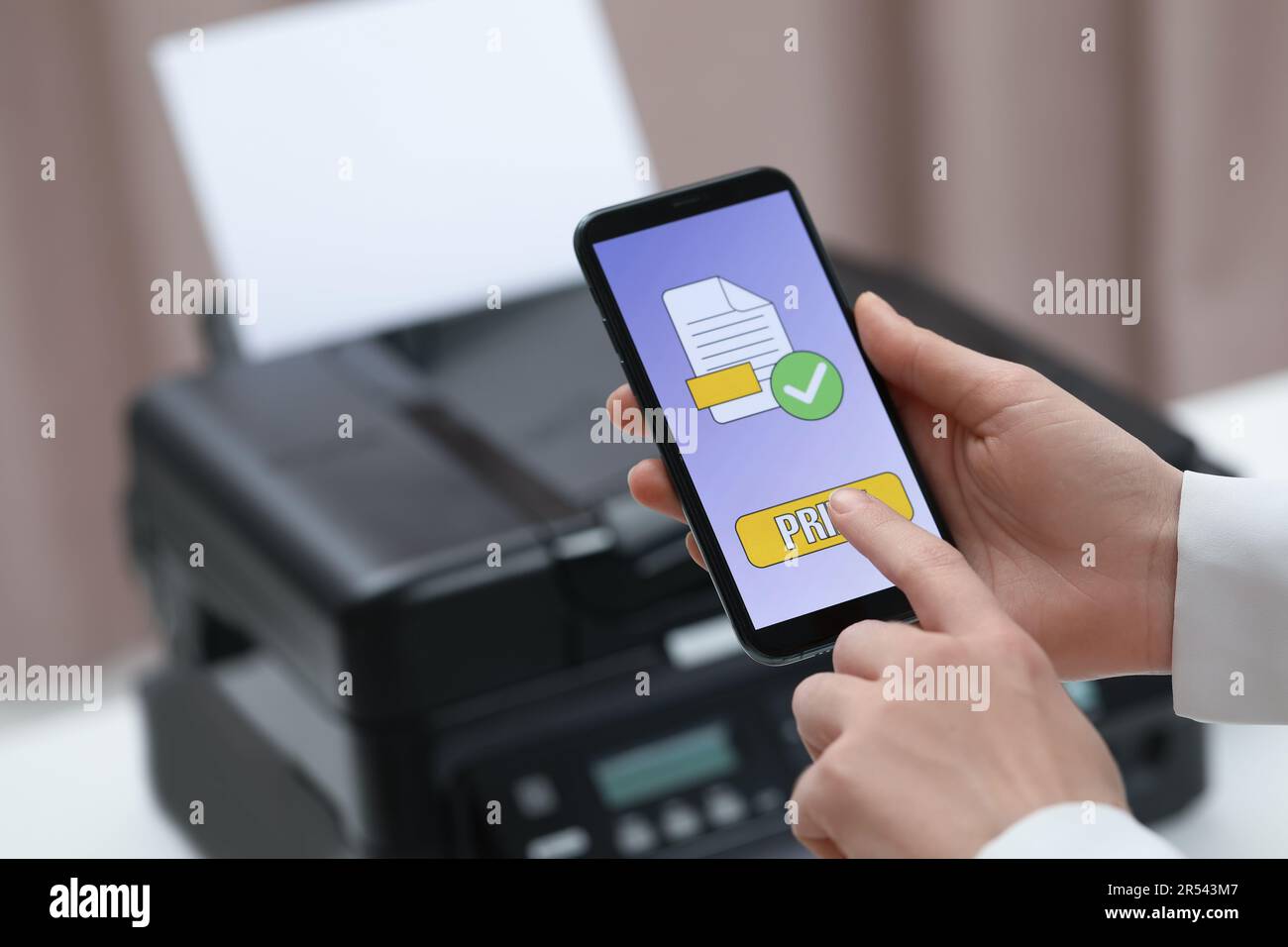 Man using printer management application on mobile phone indoors, closeup and space for text Stock Photo