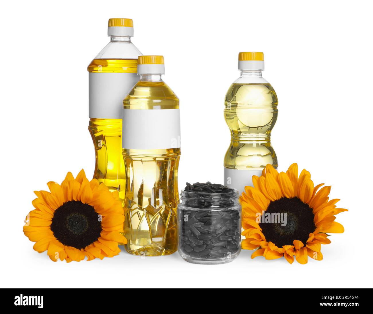 Bottles of sunflower cooking oil, seeds and yellow flowers on white