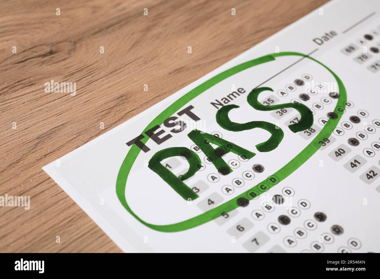 Answer sheet with word Pass on wooden table, closeup. Student passing ...