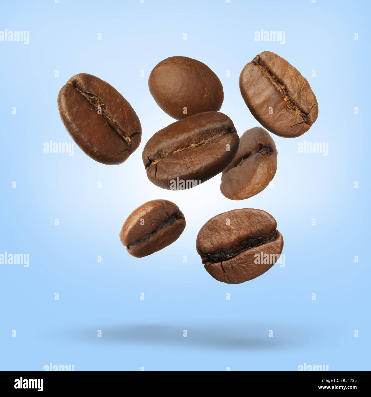 Many roasted coffee beans falling on pale light blue background Stock ...