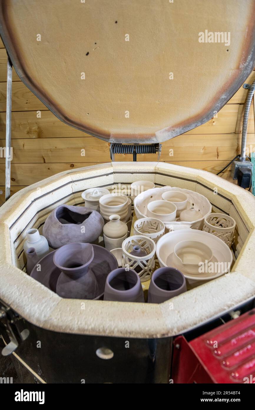 Handmade pottery pieces ready inside the kiln for firing process Stock