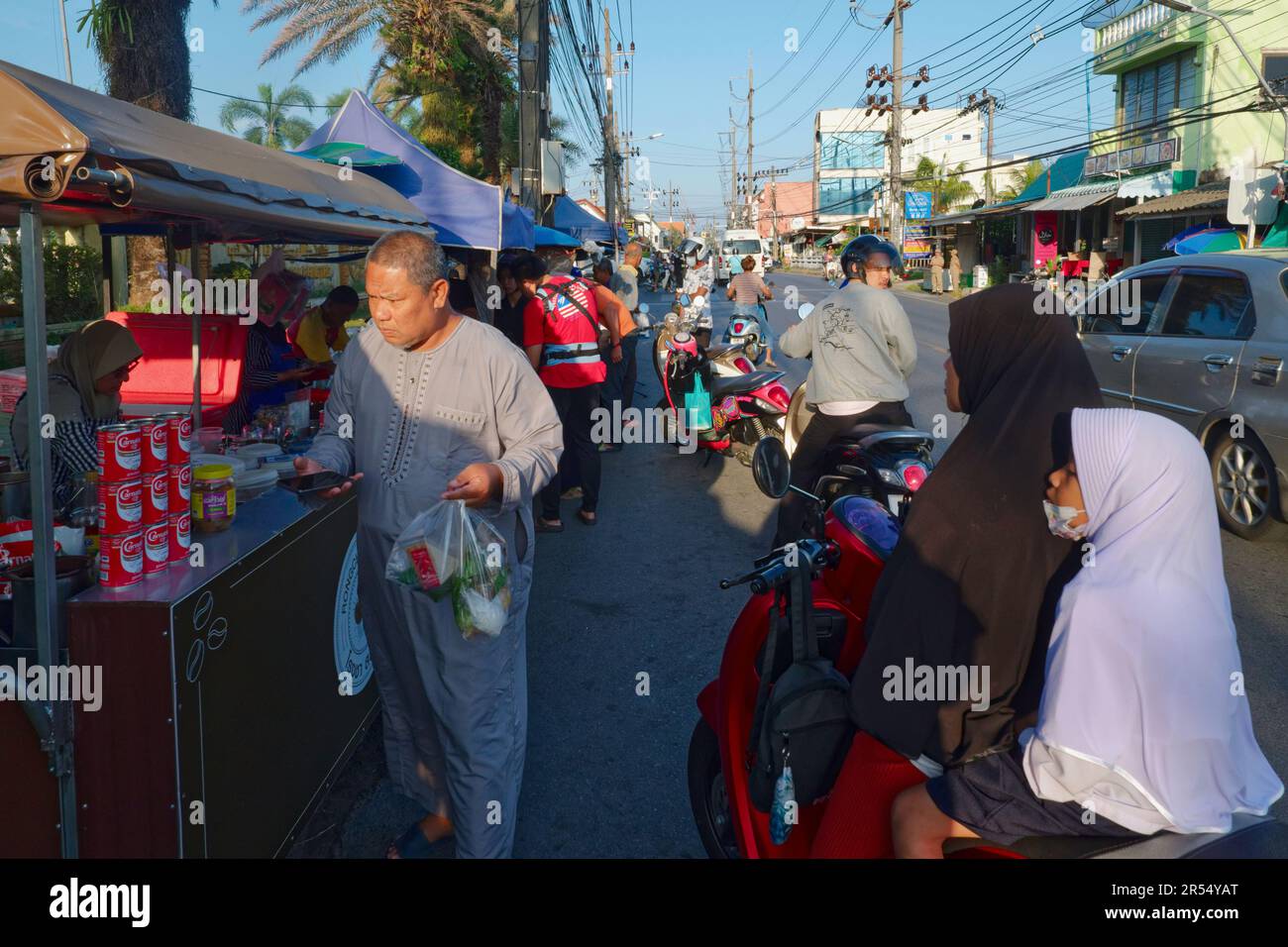 Street scene with food stalls and Muslim customers in Muslim-dominated Bang Tao township in the island of Phuket, Southern Thailand Stock Photo