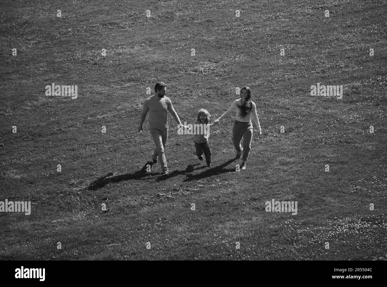 Arial view of mother father and child son having fun outdoors at summer park. Stock Photo