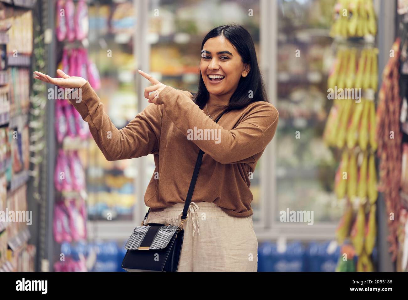 Discount, grocery and shopping with woman in supermarket for sale, product deal and food. Choice, offer and happy with female customer in groceries Stock Photo