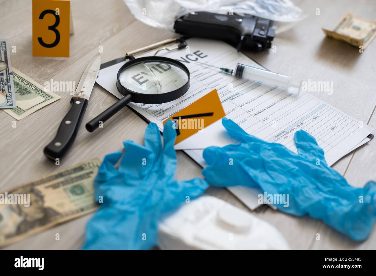 a gun lying on the ground next to a crime scene marker Stock Photo - Alamy