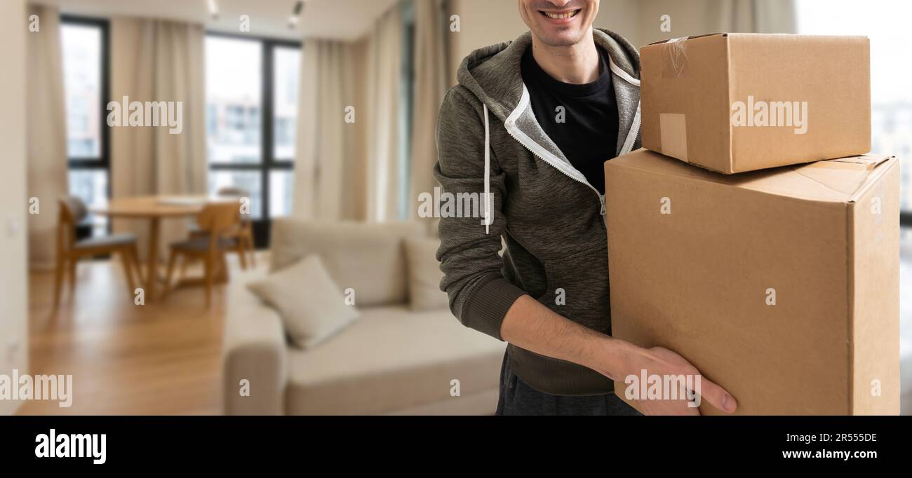 Man lifting cardboard boxes in apartment interior Stock Photo - Alamy
