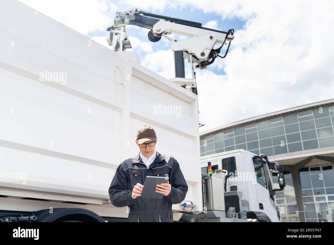 Manager with a digital tablet next to garbage truck. High quality photo Stock Photo