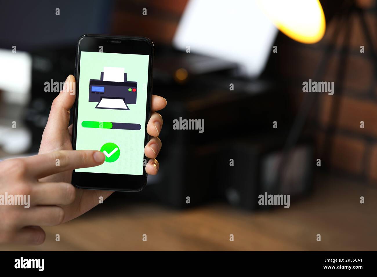 Man using printer management application on mobile phone indoors, closeup and space for text Stock Photo