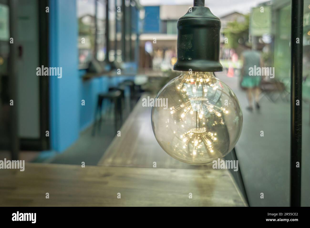 Light bulk above table outside a restaurant in city street. Auckland. Stock Photo