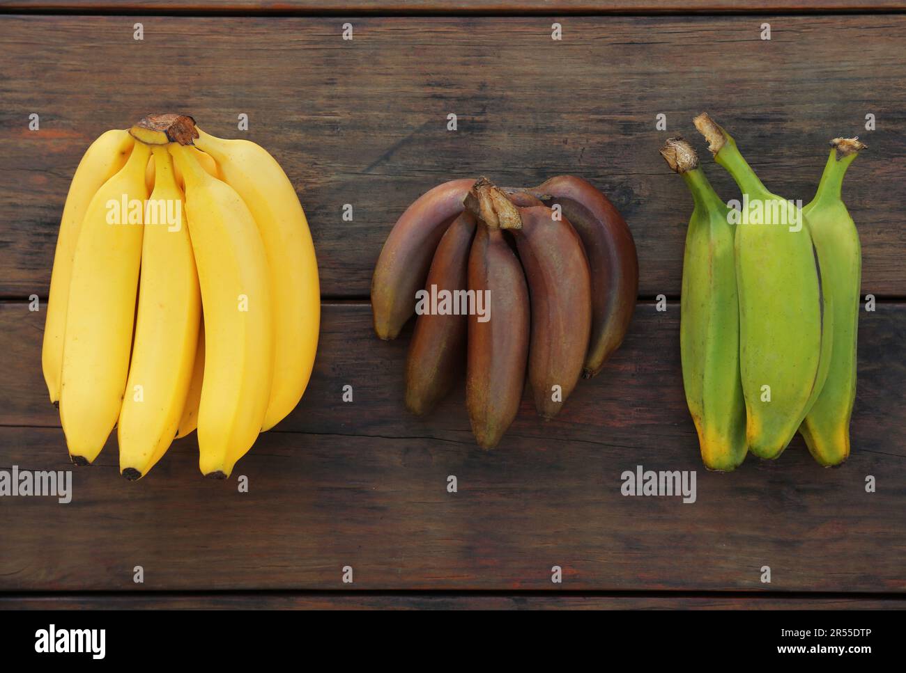 Different types of bananas on wooden table, flat lay Stock Photo