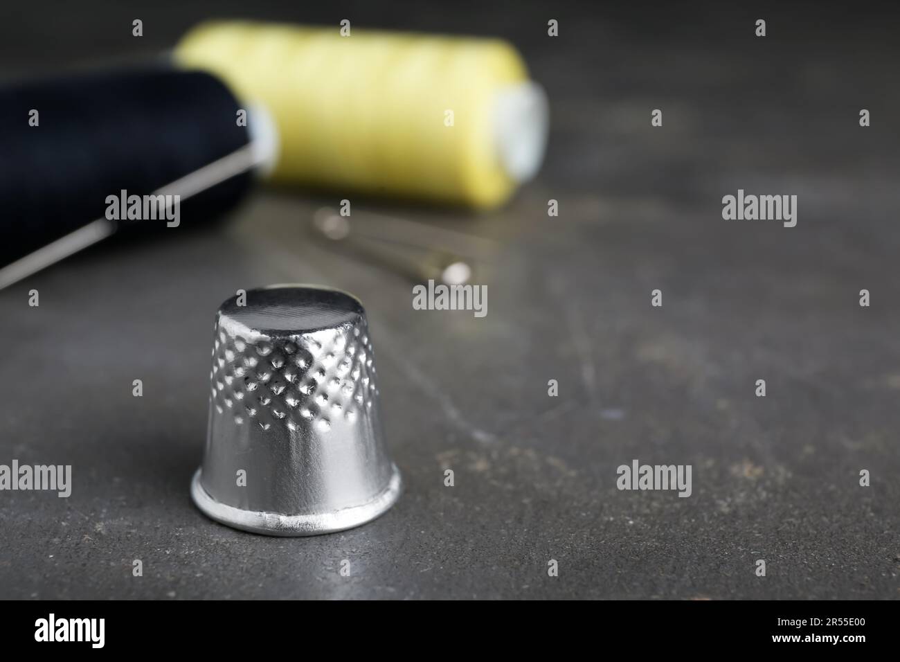 Silver sewing thimble on grey table, closeup. Space for text Stock ...