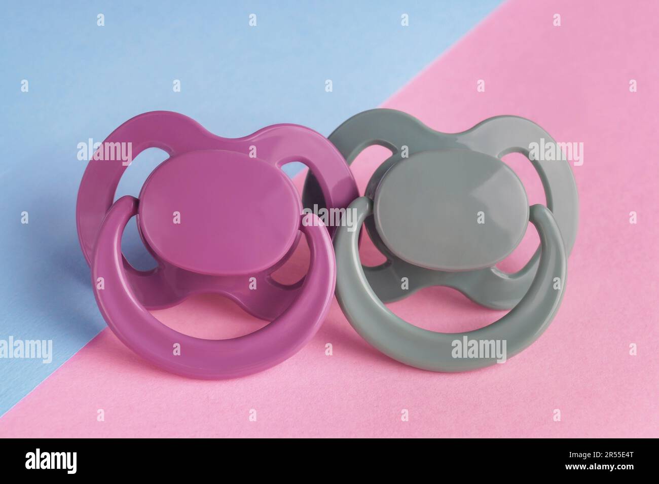New baby pacifiers on color background, closeup Stock Photo