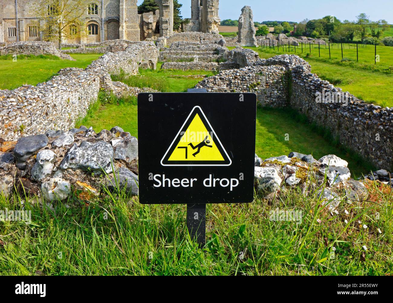 A Sheer Drop safety notice within the confines of the ruins and Priory Church of St Mary and the Holy Cross at Binham, Norfolk, England, UK. Stock Photo