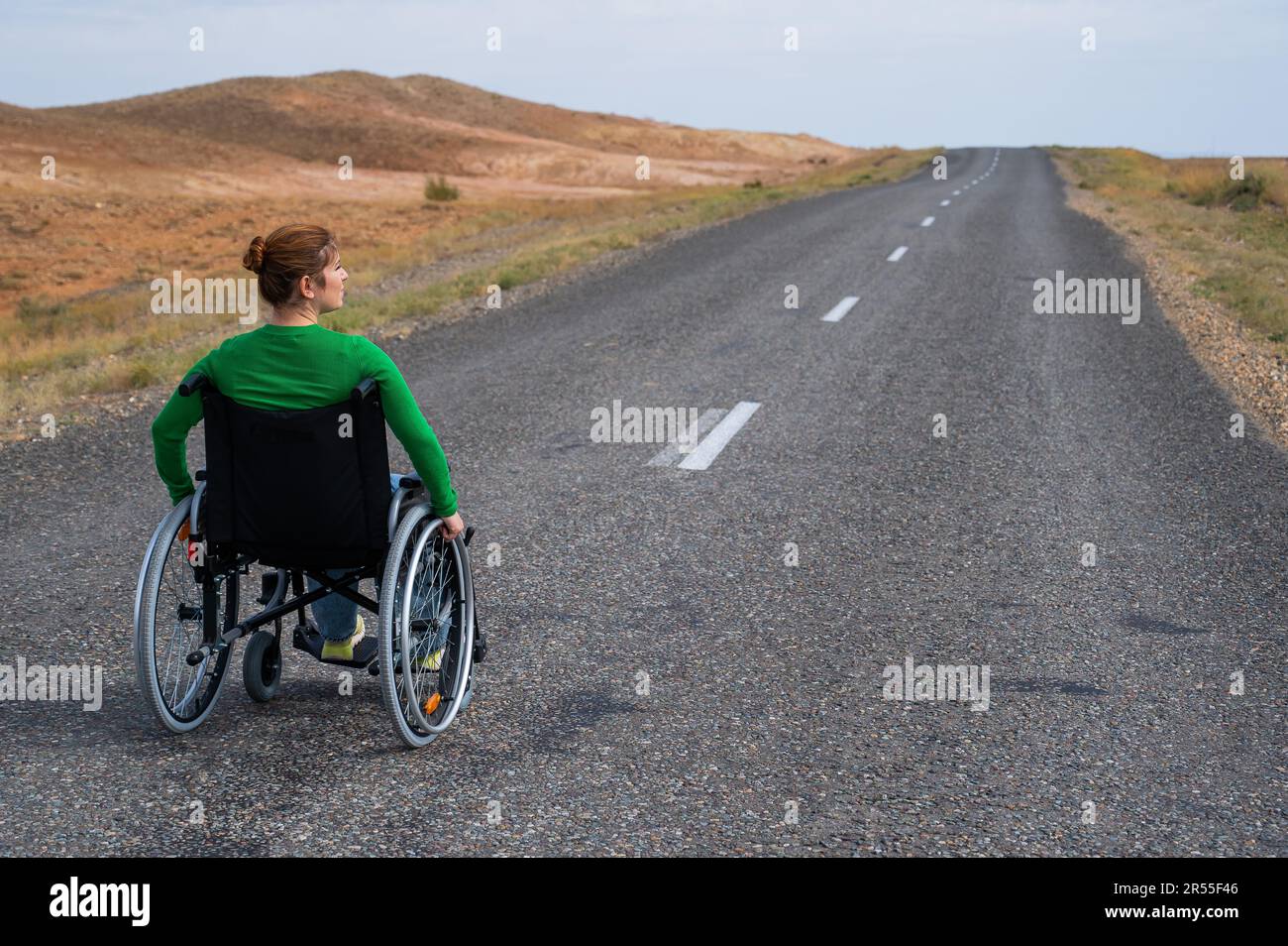 Woman in a wheelchair on a highway in the steppes Stock Photo Alamy