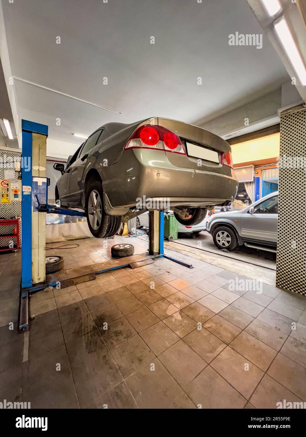 Car on lift, low angle view. Car repair shop concept Automobile service interior background