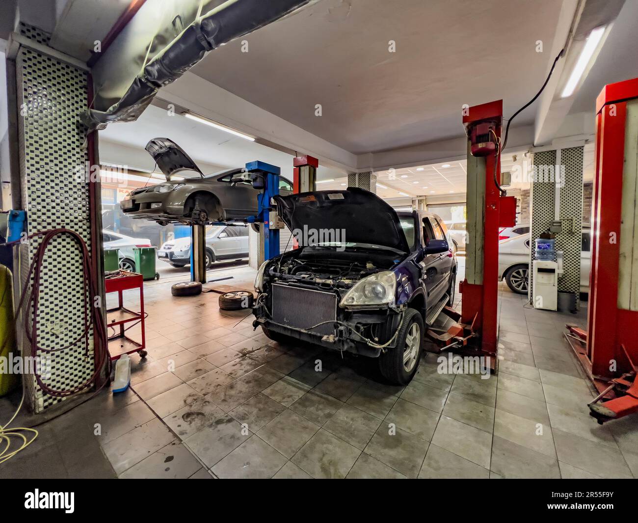 Cars at repair shop. Car repair shop concept: Automobile service interior  background with cars on lift. Maintenance costs. Car accident insurance  Stock Photo - Alamy