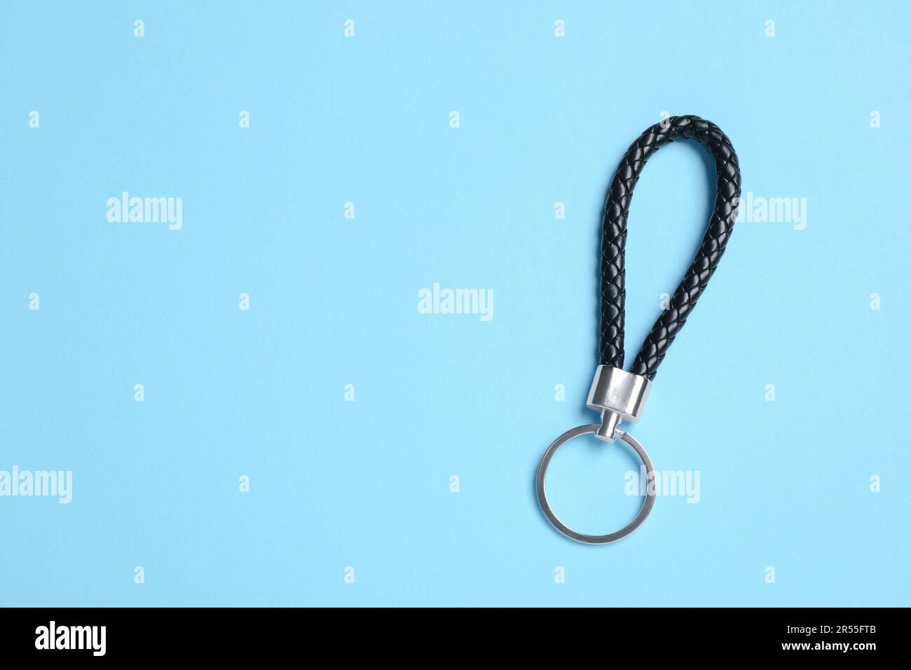 Black leather keychain on light blue background, top view. Space for text Stock Photo