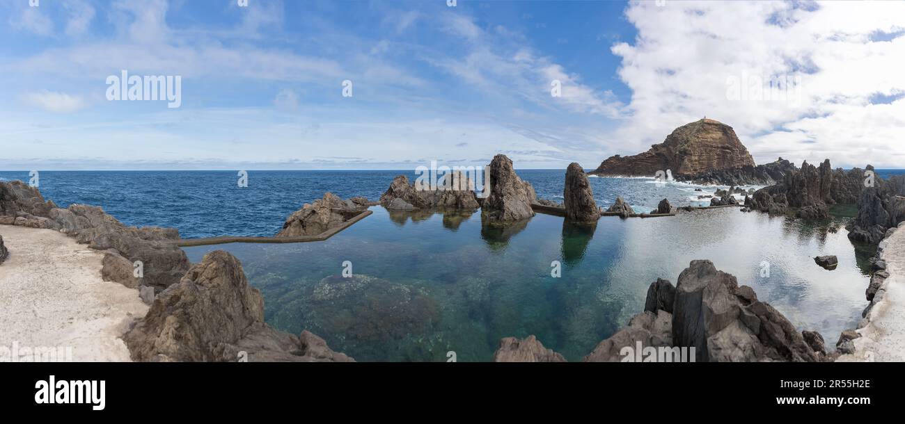 Madeira Island Portugal - 04 19 2023: Panoramic view of the natural pools on village of Porto Moniz, formed by volcanic rocks, islet of Mole in the ba Stock Photo